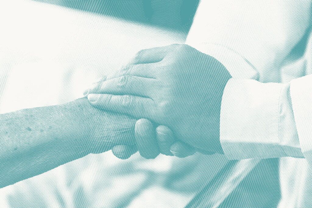 a doctor holds the hand of an older patient