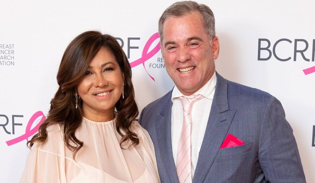 Bill and Sinesia Karol pose at a BCRF event wearing formalwear with the BCRF logo behind them
