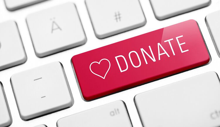A keyboard with one of the keys printed with the word "donate" and a heart