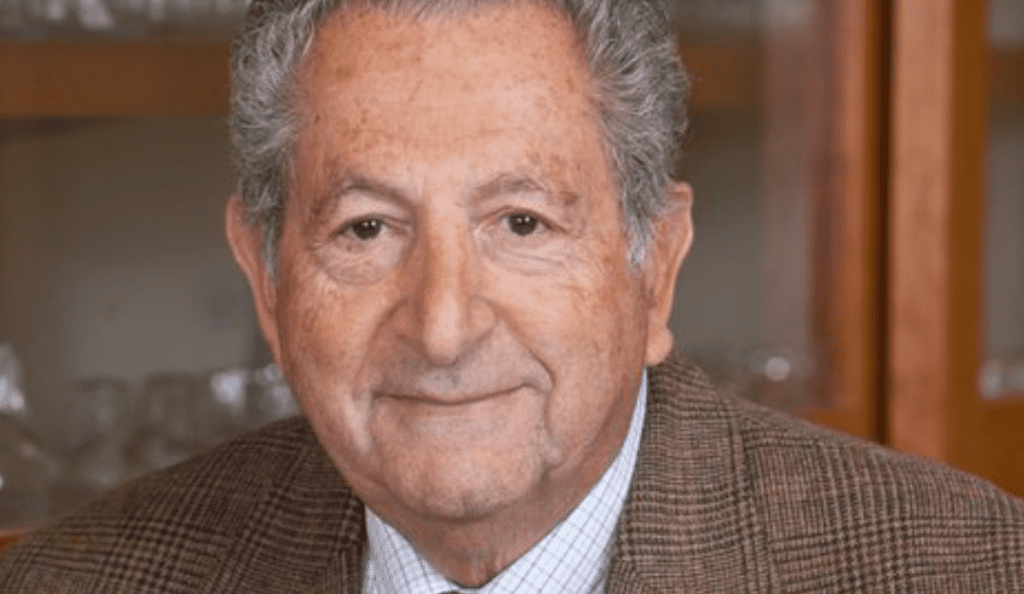 a portrait of joseph bertino wearing a tweed jacket smiling at the camera