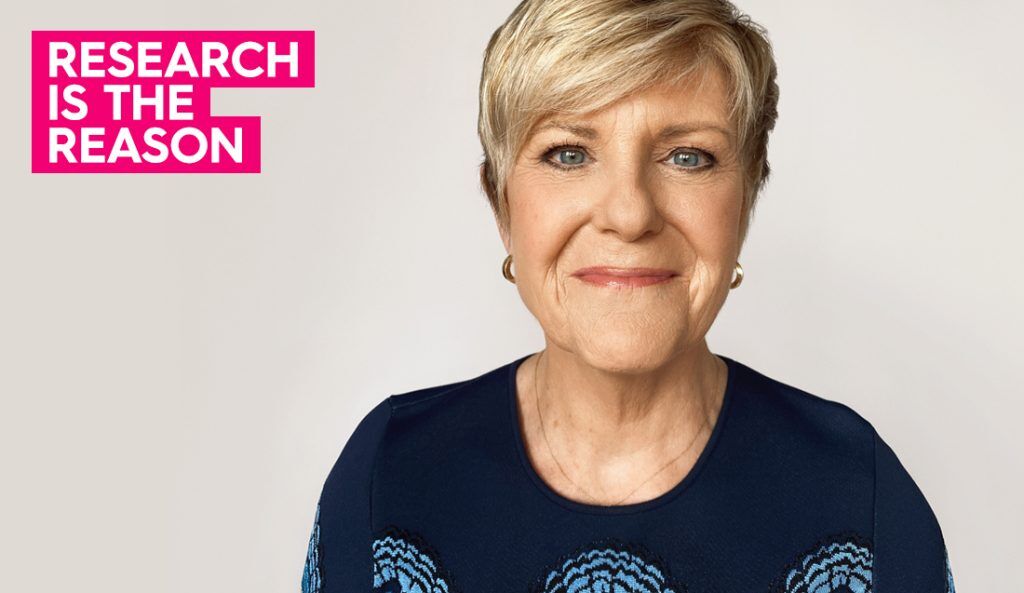 a portrait of anne thompson smiling at the camera and wearing a blue sweater