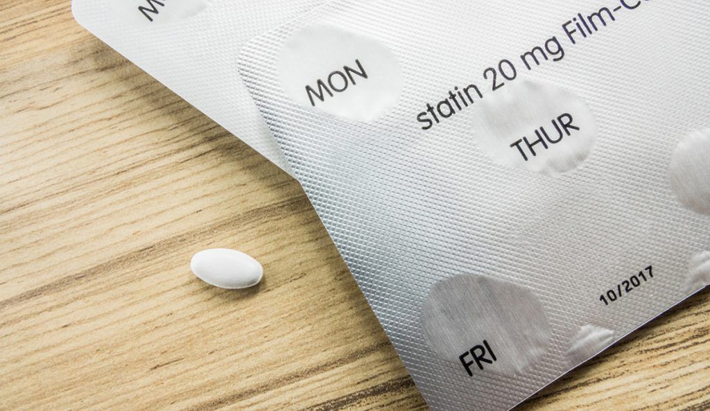 pill pack of statins (cholesterol medication) on wood table