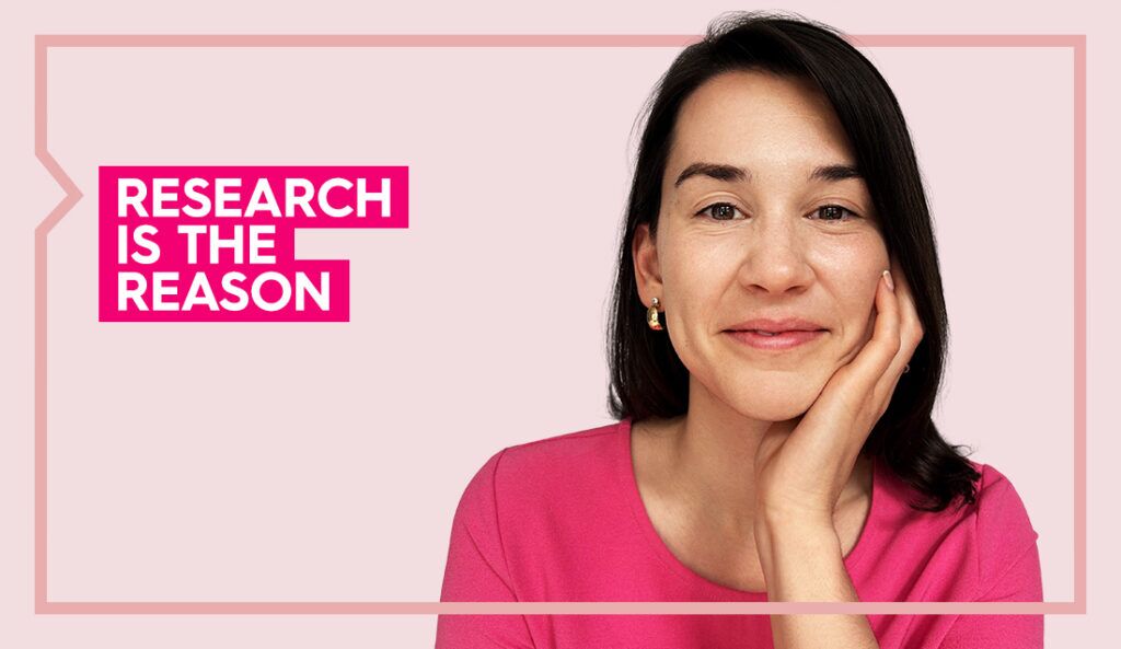 Madeline wears a pink top and rests her head on her hand looking at the camera against a light pink background