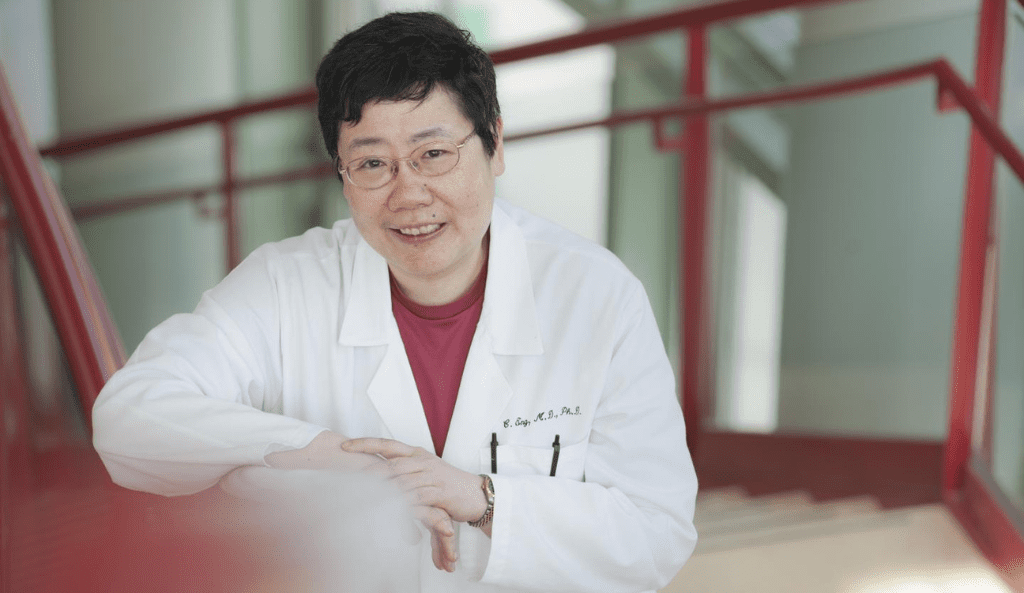 a portrait of dr. charis eng standing in a stairwell