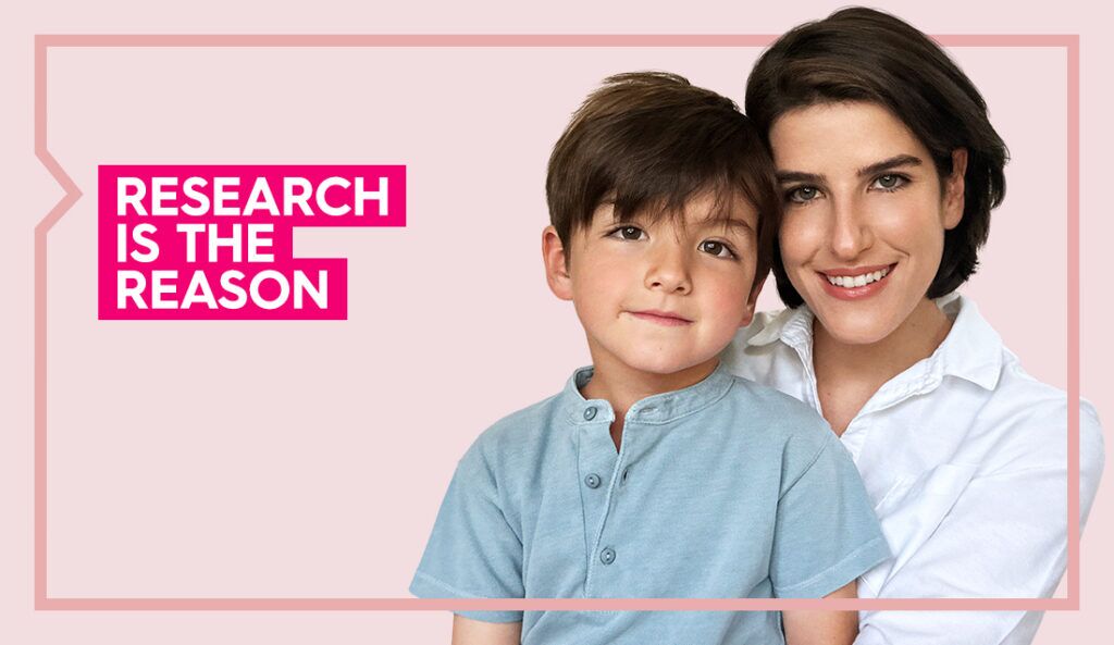 a portrait of marcella and her son smiling at the camera against a light pink background