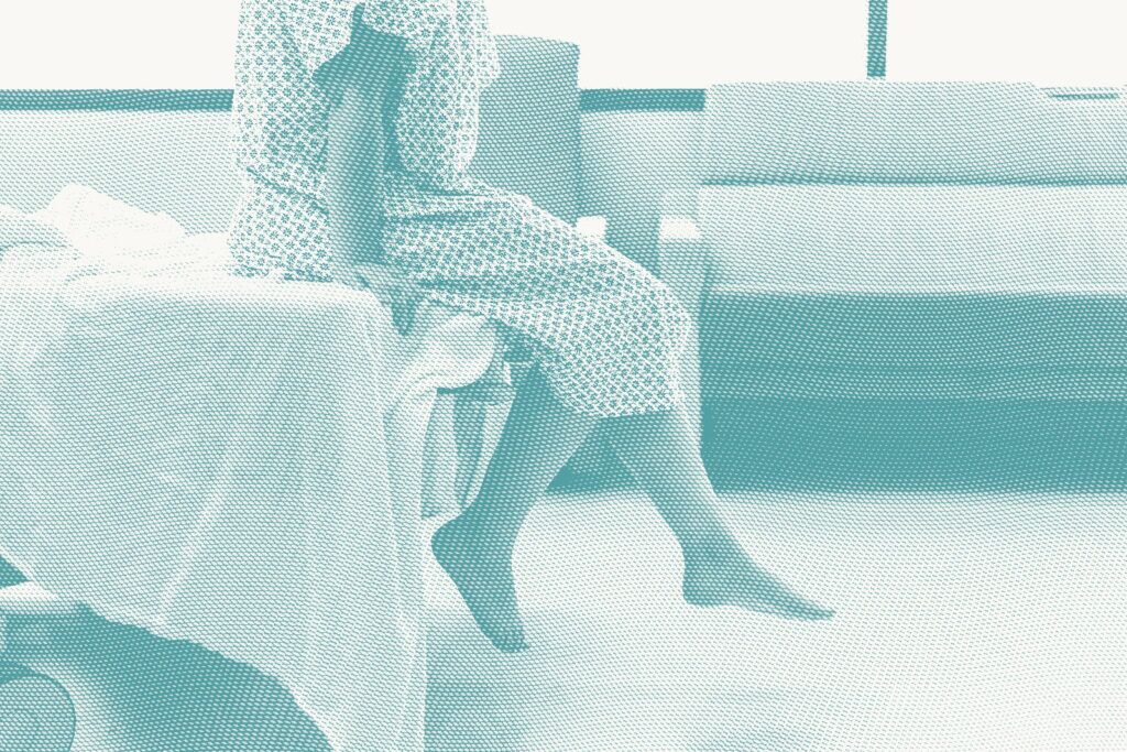 A woman wearing a hospital gown waits for a procedure