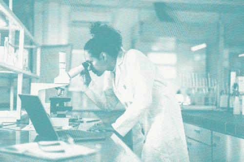 a pathologist looks into a microscope in a lab; a pathologist determines breast cancer grade