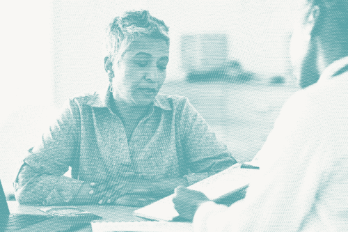 a woman speaks with her doctor; illustrative of a conversation about breast cancer recurrence