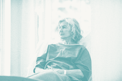 an older woman wearing a hospital gown waits for a lumpectomy