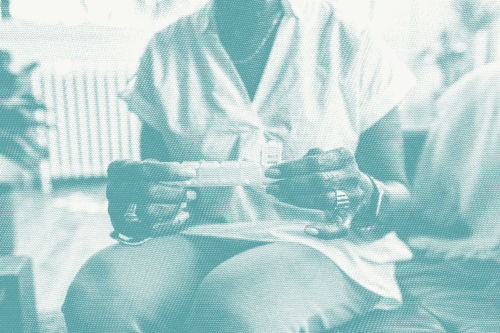 an older woman looks at a pill organizer to take hormone therapy for breast cancer