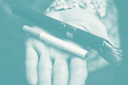 a woman holds out her hand holding a cigarette and vape pen