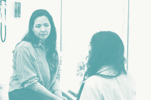 A woman talking to her doctor. She has a concerned expression