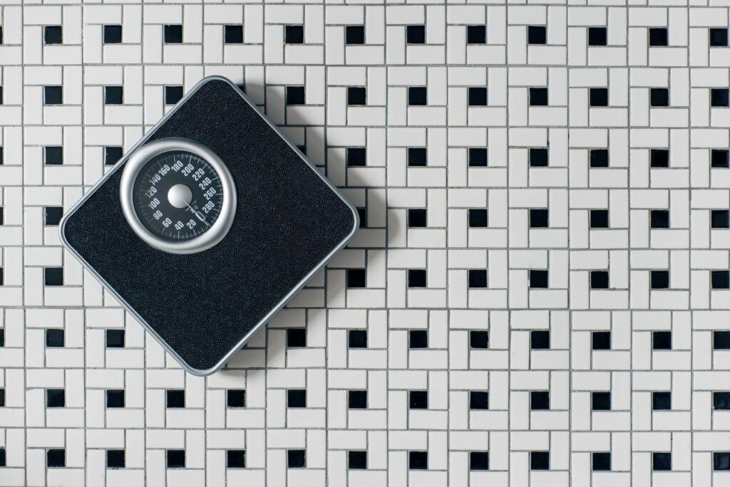 A bathroom scale on a tiled floor