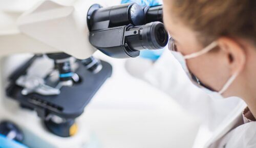 A female scientist looking into a microscope