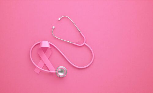 A pink ribbon is interspersed with a pink stethoscope against a pink background