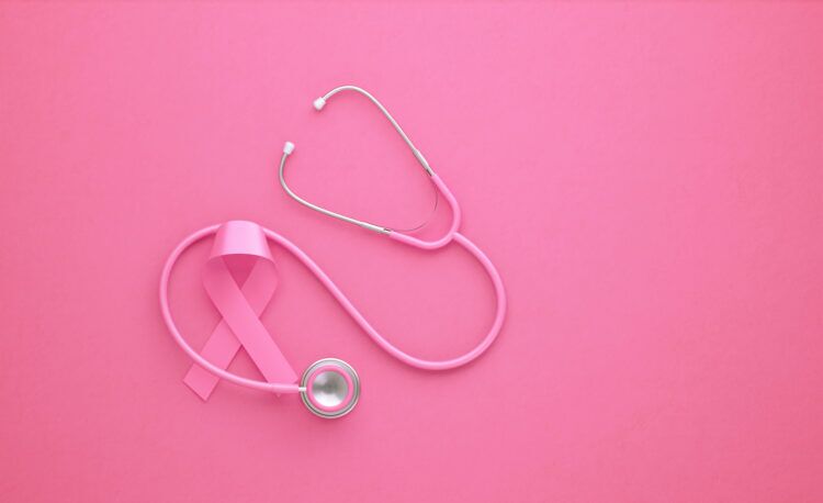 A pink ribbon is interspersed with a pink stethoscope against a pink background